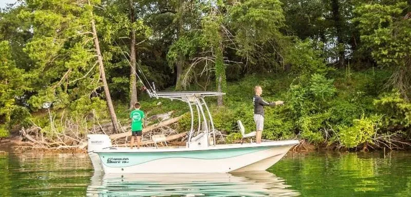 The Image of 2026 Carolina Skiff 19 LS boat on calm water with green backdrop. - 1