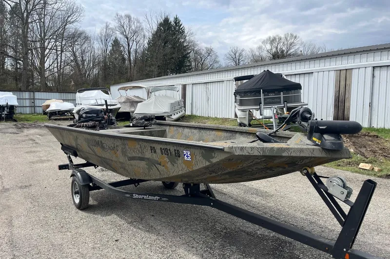 Slide: The Image of 2022 Alumacraft 1650 All Weld MV Tiller boat on trailer, parked outdoors. - 6