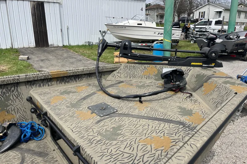 Slide: The Image of 2022 Alumacraft 1650 All Weld MV Tiller boat with camo interior and trolling motor. - 7