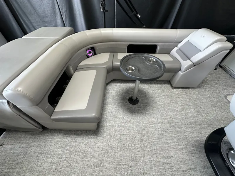 Slide: The Image of Interior of 2024 Premier 230 Sunsation TRITOON with gray seating and table. - 25