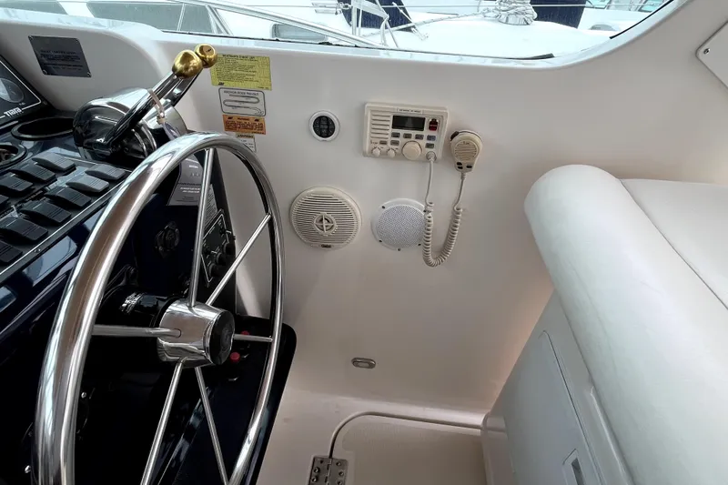 Slide: The Image of 1999 Tiara Yachts 3500 Open helm with steering wheel and communication equipment. - 26