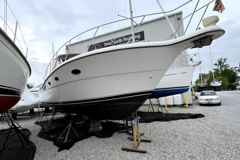 Slide: The Image of 1999 Tiara Yachts 3500 Open on stands at a marina, ready for maintenance. - 2