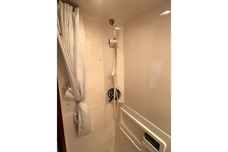 Slide: The Image of Shower area in 1999 Tiara Yachts 3500 Open, featuring white curtain and handheld showerhead. - 16