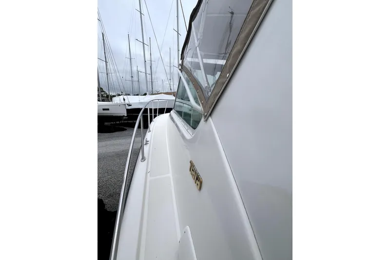 Slide: The Image of 1999 Tiara Yachts 3500 Open, side view, docked with sailboats in the background. - 31