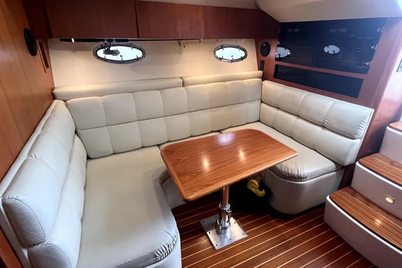 Slide: The Image of 1999 Tiara Yachts 3500 Open interior with plush seating and wooden table. - 6