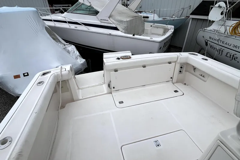 Slide: The Image of 1999 Tiara Yachts 3500 Open boat deck, white and spacious, in a marina setting. - 23