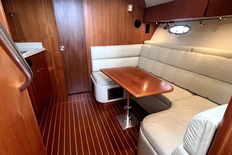 Slide: The Image of 1999 Tiara Yachts 3500 Open interior with wood paneling and cushioned seating. - 5