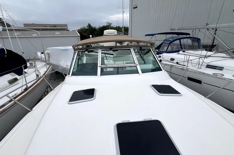 Slide: The Image of 1999 Tiara Yachts 3500 Open docked among other boats, showcasing sleek design and spacious deck. - 44