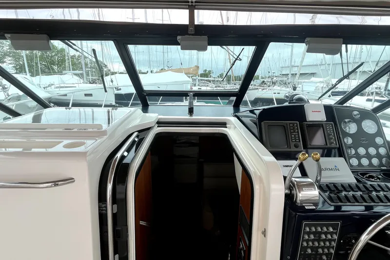 Slide: The Image of 1999 Tiara Yachts 3500 Open helm with navigation equipment and marina view. - 25
