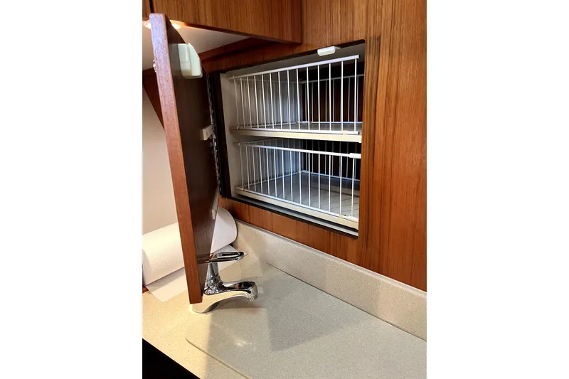 Slide: The Image of Wooden cabinet with open door revealing wire shelves in 1999 Tiara Yachts 3500 Open. - 10