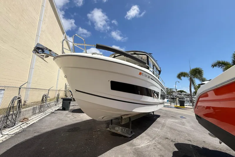 The Image of 2021 Jeanneau NC 895 boat on dry dock under clear blue sky. - 1