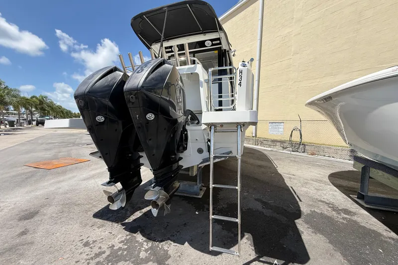 Slide: The Image of 2021 Jeanneau NC 895 boat with dual outboard motors and ladder, parked outdoors. - 11