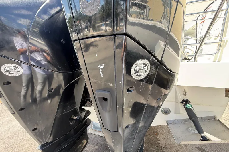 Slide: The Image of 2021 Jeanneau NC 895 boat with dual outboard motors, featuring ultra-low emission stickers. - 13