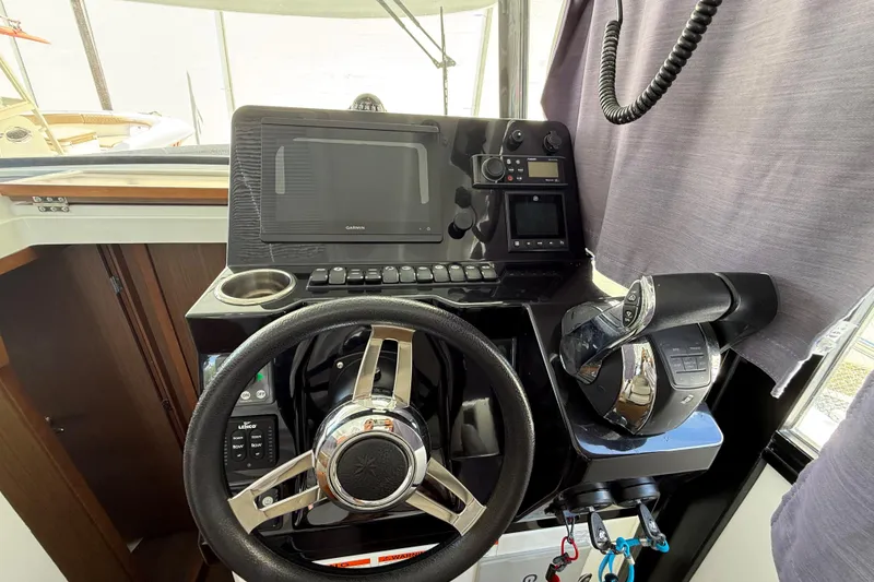 Slide: The Image of 2021 Jeanneau NC 895 helm with steering wheel, navigation system, and controls. - 21