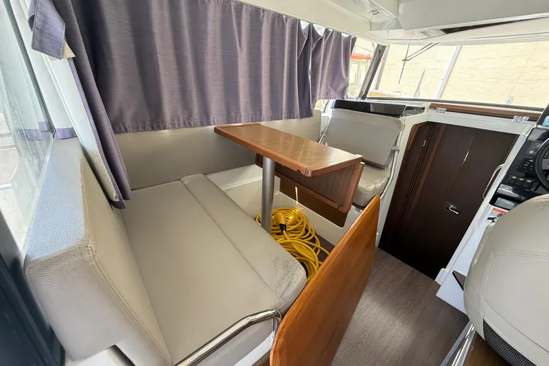 Slide: The Image of Interior of 2021 Jeanneau NC 895 boat with seating, table, and curtains. - 22