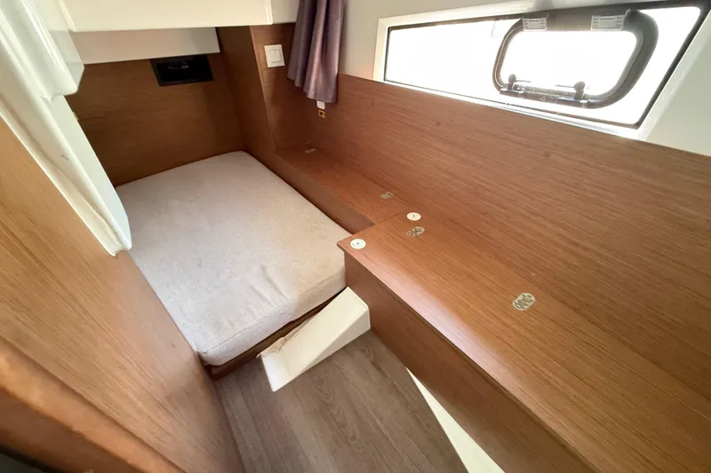 Slide: The Image of 2021 Jeanneau NC 895 cabin interior with wooden finish and compact bed. - 26