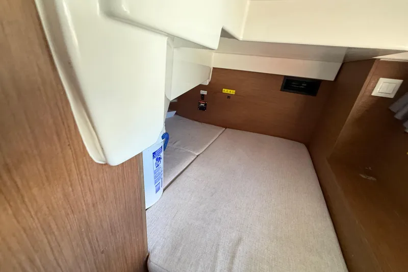 Slide: The Image of 2021 Jeanneau NC 895 cabin interior with wooden finish and cozy bedding. - 27