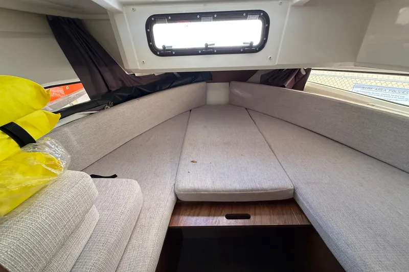 Slide: The Image of Cozy cabin interior of 2021 Jeanneau NC 895 boat with cushioned seating and window. - 28