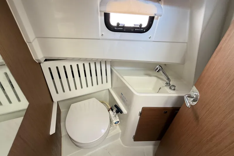 Slide: The Image of Compact bathroom in 2021 Jeanneau NC 895 boat with toilet, sink, and window. - 31