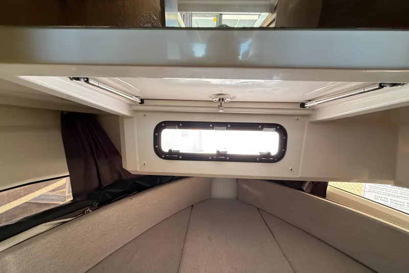 Slide: The Image of Interior cabin view of 2021 Jeanneau NC 895 boat, featuring a window and cozy seating area. - 32