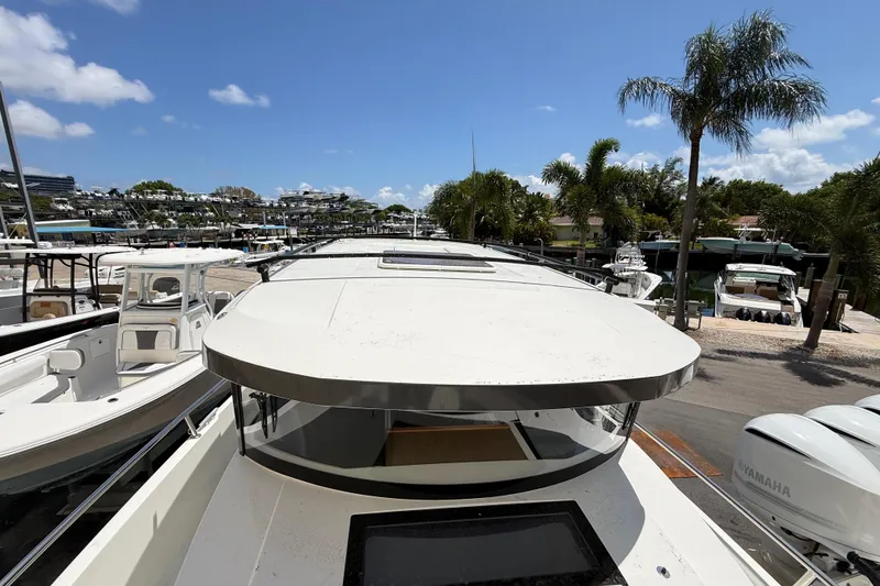 Slide: The Image of 2021 Jeanneau NC 895 boat docked at a marina with palm trees and clear skies. - 36