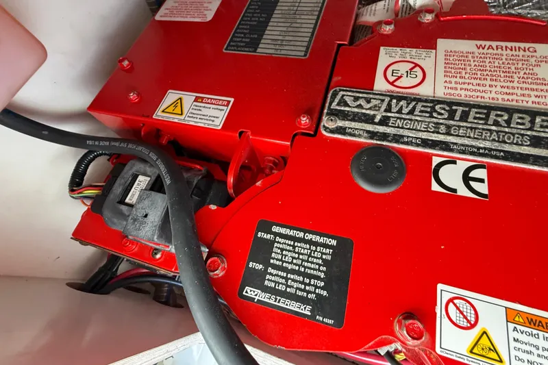 Slide: The Image of Red Westerbeke generator in a 2021 Jeanneau NC 895 boat, featuring safety labels and wiring. - 44