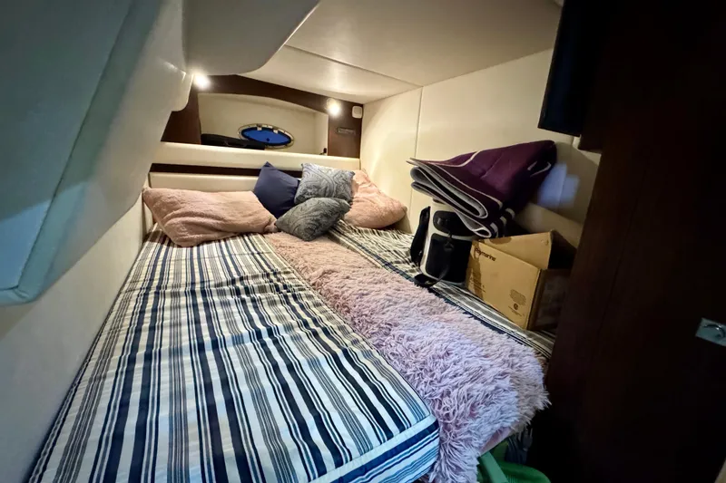 Slide: The Image of Cozy cabin interior of 2012 Cruisers Yachts 430 Sports Coupe with striped bedding and cushions. - 17