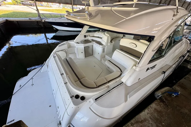 Slide: The Image of 2012 Cruisers Yachts 430 Sports Coupe in dock, showcasing spacious seating and sleek design. - 2
