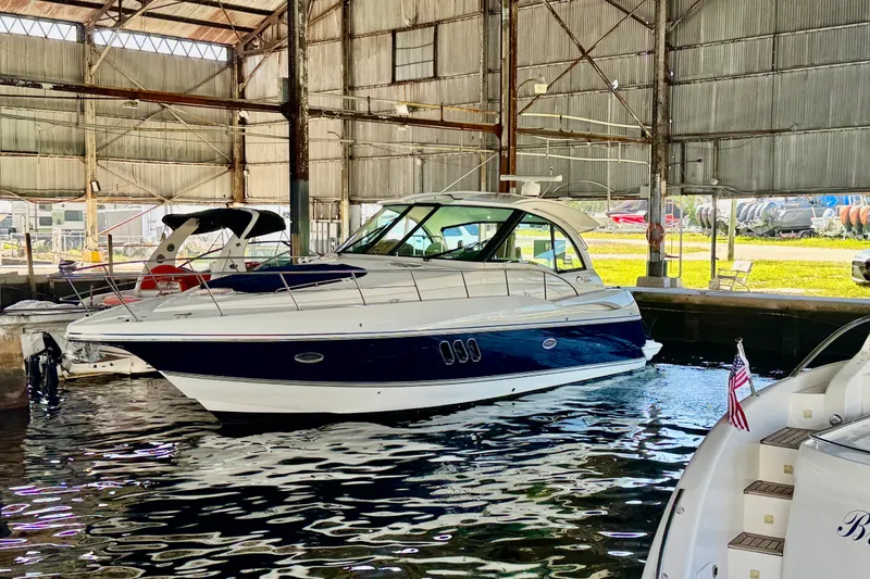 Slide: The Image of 2012 Cruisers Yachts 430 Sports Coupe docked in a marina under a metal roof. - 26