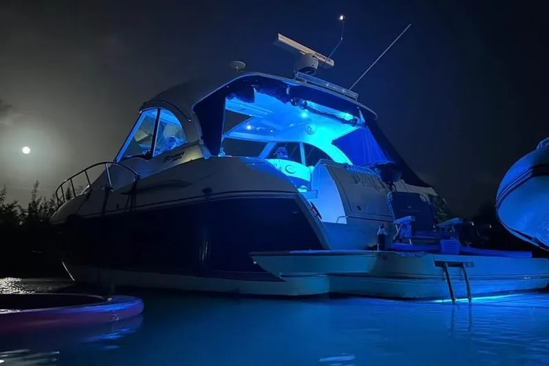 Slide: The Image of 2012 Cruisers Yachts 430 Sports Coupe illuminated at night on the water. - 27