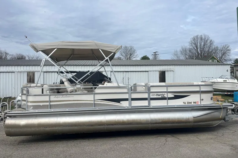 The Image of 2008 Harris Super Sunliner 240 pontoon boat with canopy, parked outdoors. - 1
