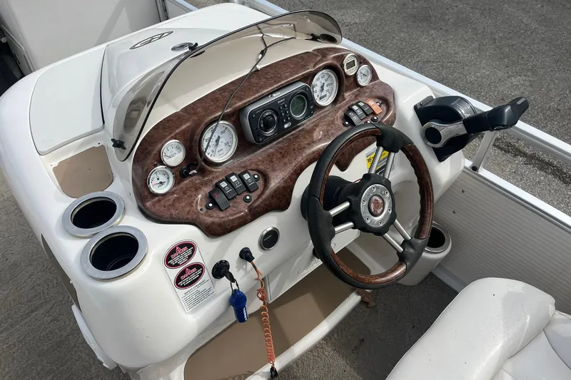 Slide: The Image of 2008 Harris Super Sunliner 240 boat dashboard with steering wheel and control panel. - 10