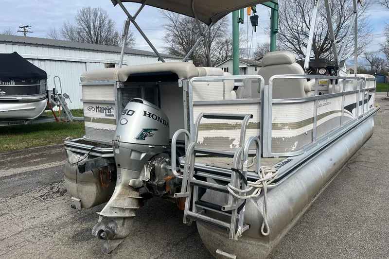 Slide: The Image of 2008 Harris Super Sunliner 240 pontoon boat with Honda 50 engine, parked outdoors. - 4