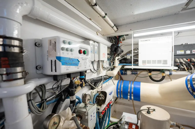 Slide: The Image of Engine room of 1983 Rybovich 55 Convertible yacht with control panels and piping. - 105