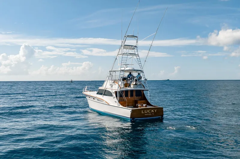 Slide: The Image of 1983 Rybovich 55 Convertible yacht "Lucky" cruising on open ocean under clear skies. - 106