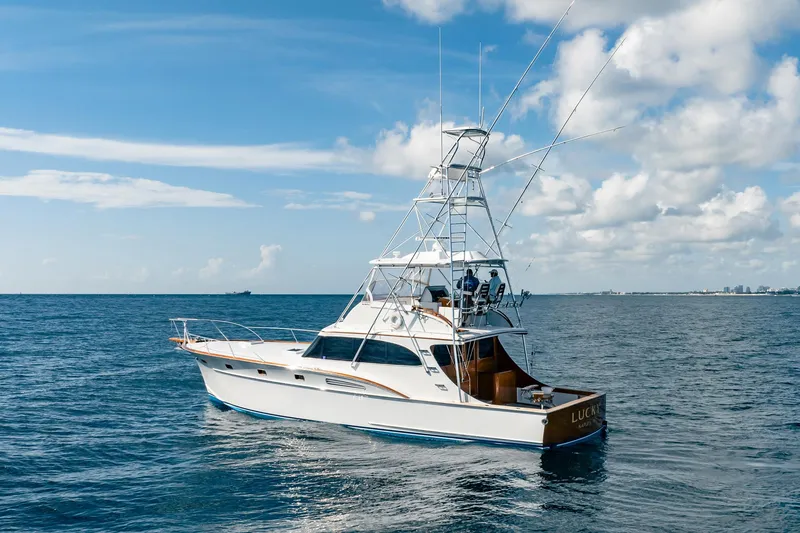 Slide: The Image of 1983 Rybovich 55 Convertible yacht cruising on open sea under blue sky. - 109