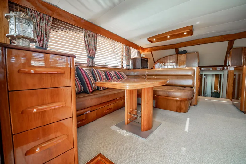 Slide: The Image of Luxurious interior of a 1983 Rybovich 55 Convertible yacht with wood finishes and seating. - 11