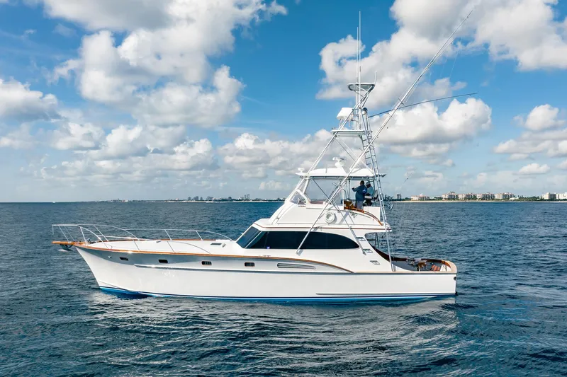 Slide: The Image of 1983 Rybovich 55 Convertible yacht cruising on open water under a blue sky. - 110