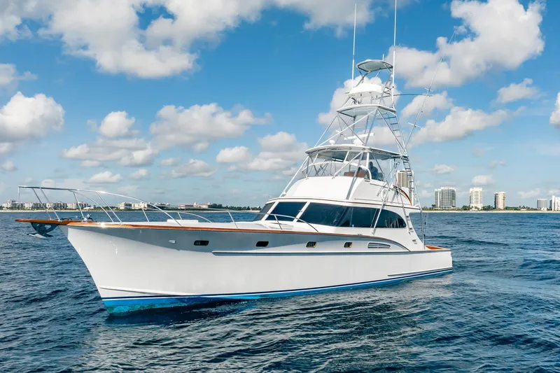 Slide: The Image of 1983 Rybovich 55 Convertible yacht on open water, under a partly cloudy sky. - 111