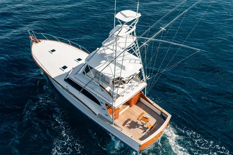 Slide: The Image of 1983 Rybovich 55 Convertible yacht cruising on open blue sea. - 117