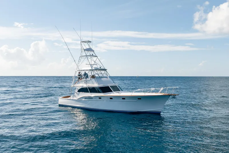 Slide: The Image of 1983 Rybovich 55 Convertible yacht cruising on open sea under clear sky. - 119