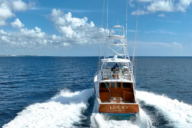Slide: The Image of 1983 Rybovich 55 Convertible yacht "Lucky" cruising on open ocean under blue sky. - 120