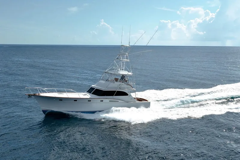 Slide: The Image of 1983 Rybovich 55 Convertible yacht cruising on open ocean under clear skies. - 124