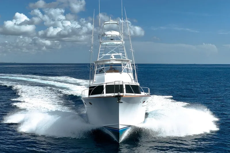 Slide: The Image of 1983 Rybovich 55 Convertible yacht cruising on open ocean under clear skies. - 127
