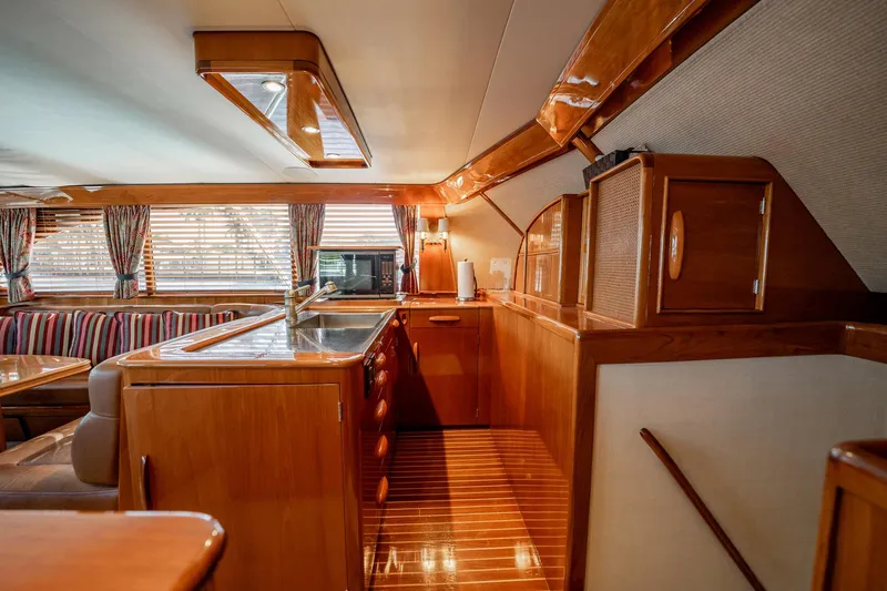 Slide: The Image of Interior of 1983 Rybovich 55 Convertible yacht with wooden cabinetry and striped seating. - 25