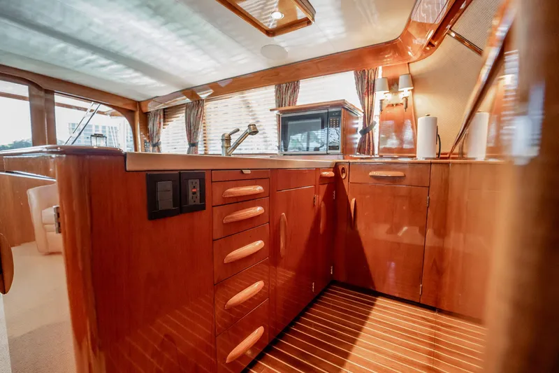 Slide: The Image of Luxurious wooden interior of 1983 Rybovich 55 Convertible yacht kitchen area. - 26