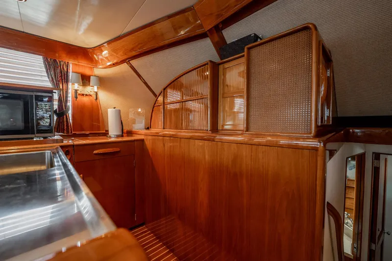 Slide: The Image of Luxurious wooden interior of a 1983 Rybovich 55 Convertible yacht kitchen area. - 29