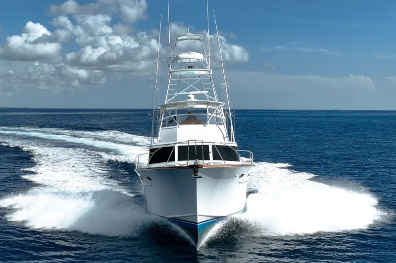 Slide: The Image of 1983 Rybovich 55 Convertible yacht cruising on open ocean under blue sky. - 3