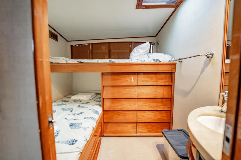 Slide: The Image of Interior of 1983 Rybovich 55 Convertible yacht with wooden bunk beds and storage. - 45