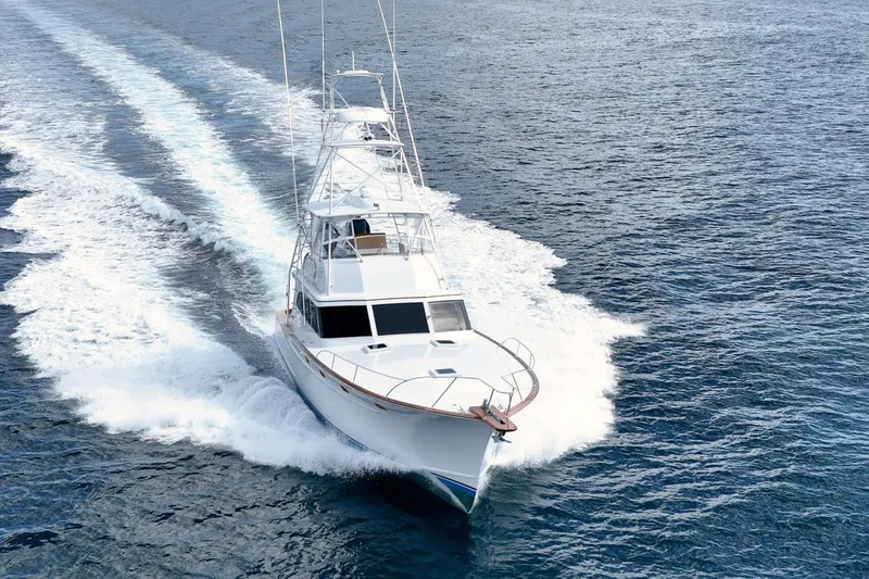 Slide: The Image of 1983 Rybovich 55 Convertible yacht cruising swiftly on open water. - 54